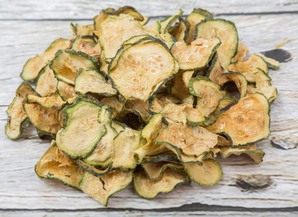Dried zucchini or courgette over wooden background