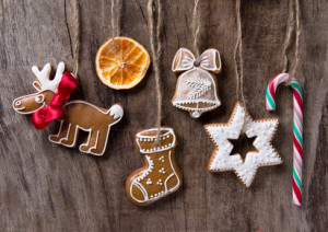 Traditional gingerbread cookies hanging over wooden background