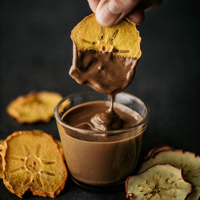 Rondella di caco intinta nel cioccolato temperato con l'essiccatore