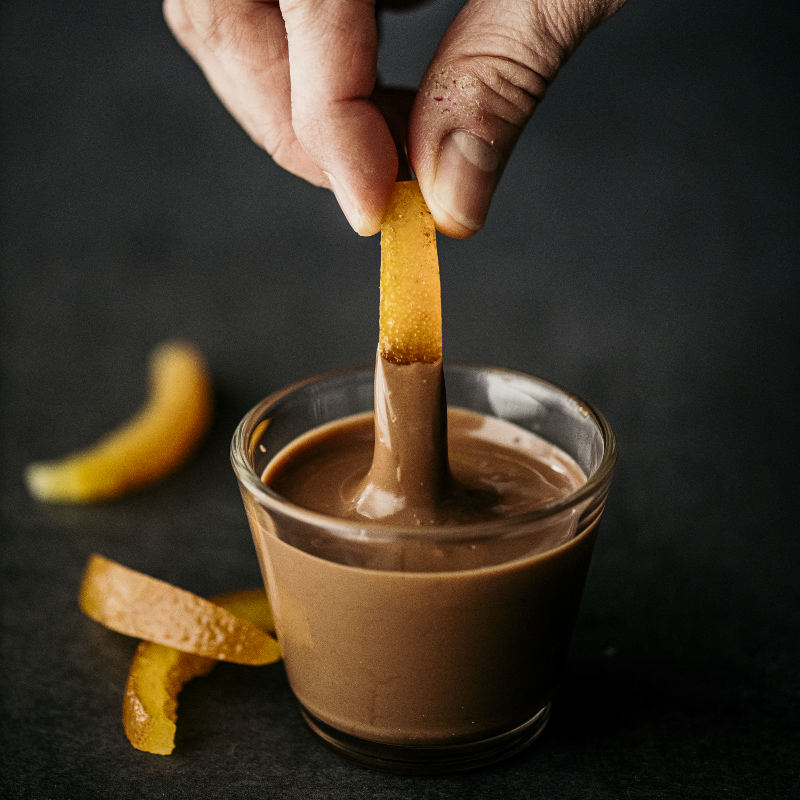 Buccia d'arancia candita intinta nel cioccolato temperato con l'essiccatore