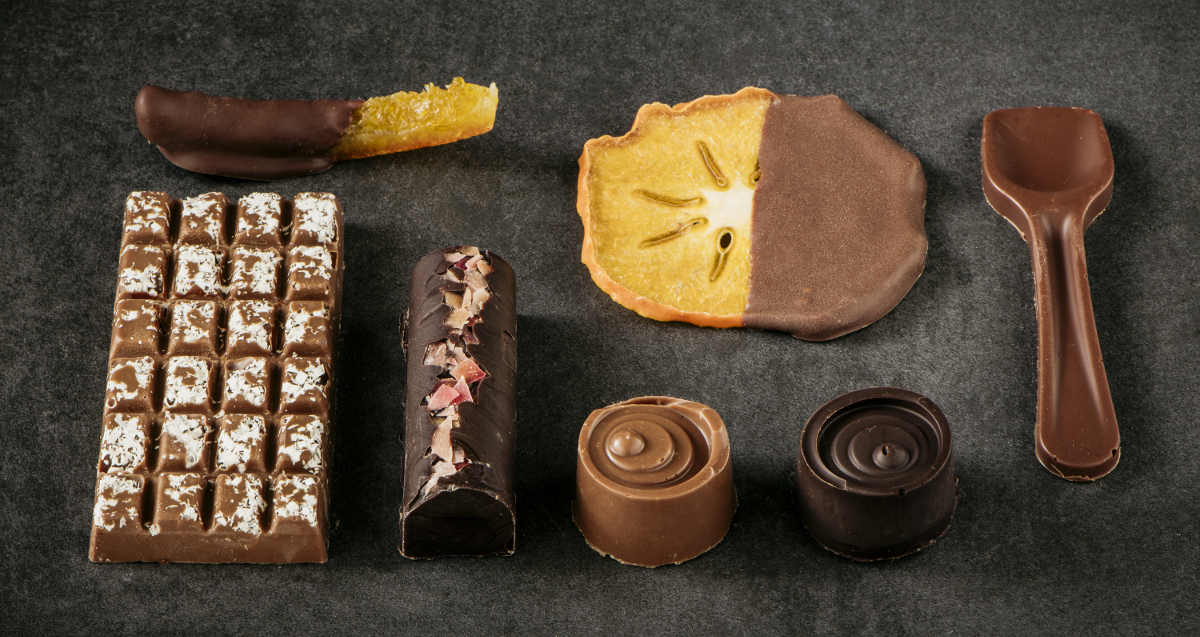 Mix di cioccolatini ripieni, barrette di cioccolata e frutta candita intinta nel cioccolato temperato con l'essiccatore