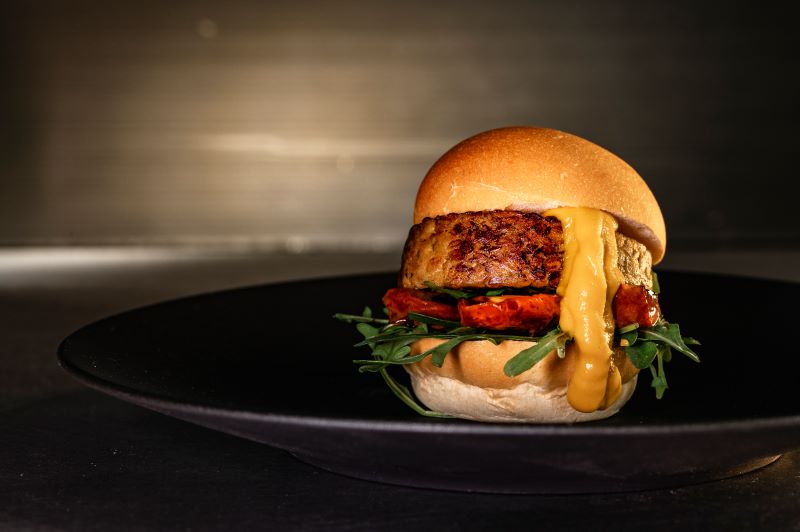 Burger di tempeh di lenticchie rosse, pomodorini infornati, rughetta e ketchup di carote
